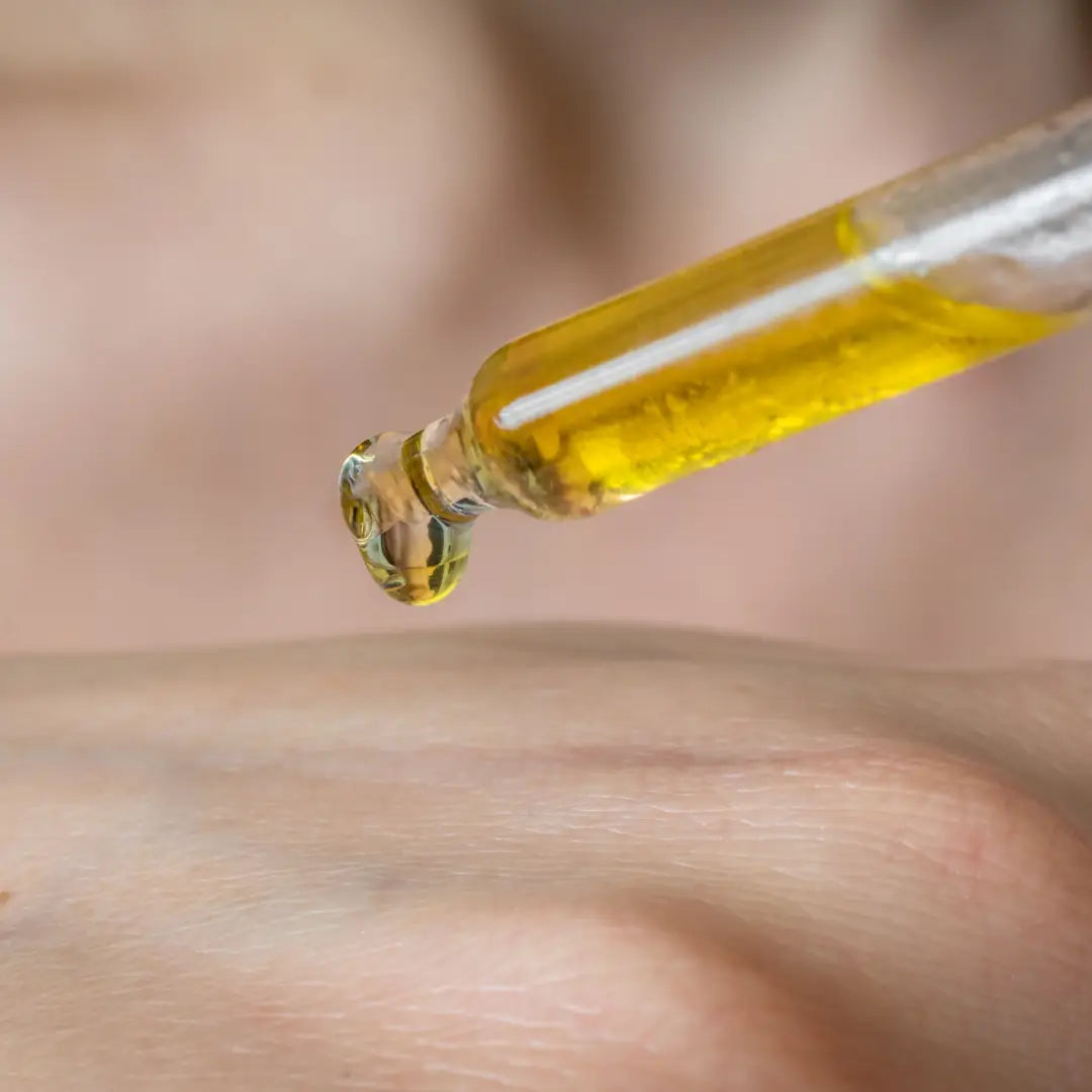 Close-up of a dropper with By Valenti Bakuchiol Smoothing Serum being applied to skin