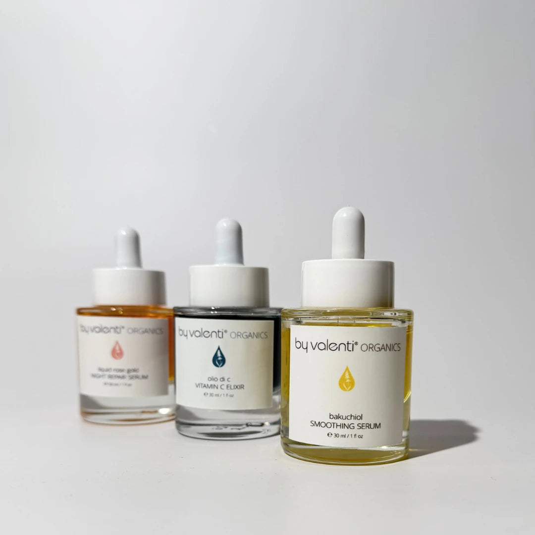 Three By Valenti skincare serum bottles from on a light gray background