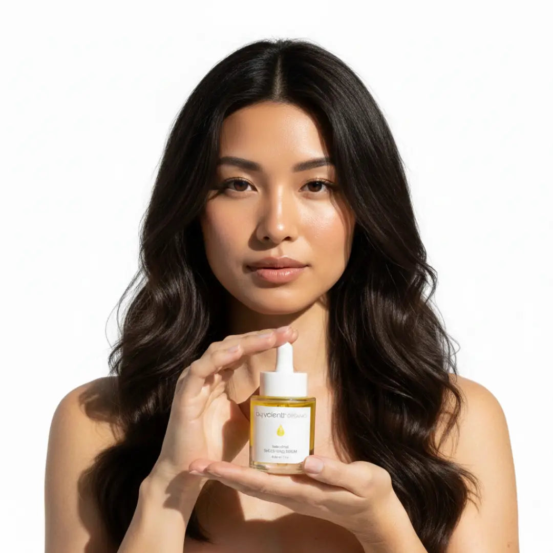 Japanese model/woman holding a bottle of BY VALENTI Bakuchiol Serum in front o a plain background
