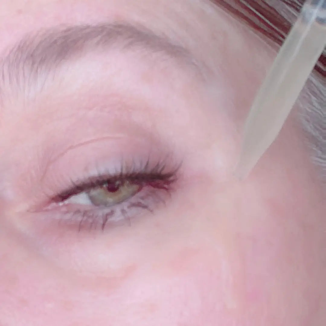 Manuela Valenti's close up of her eye applying Barcola Azzurro Mare Replenishing Serum with a dropper near her eye area.