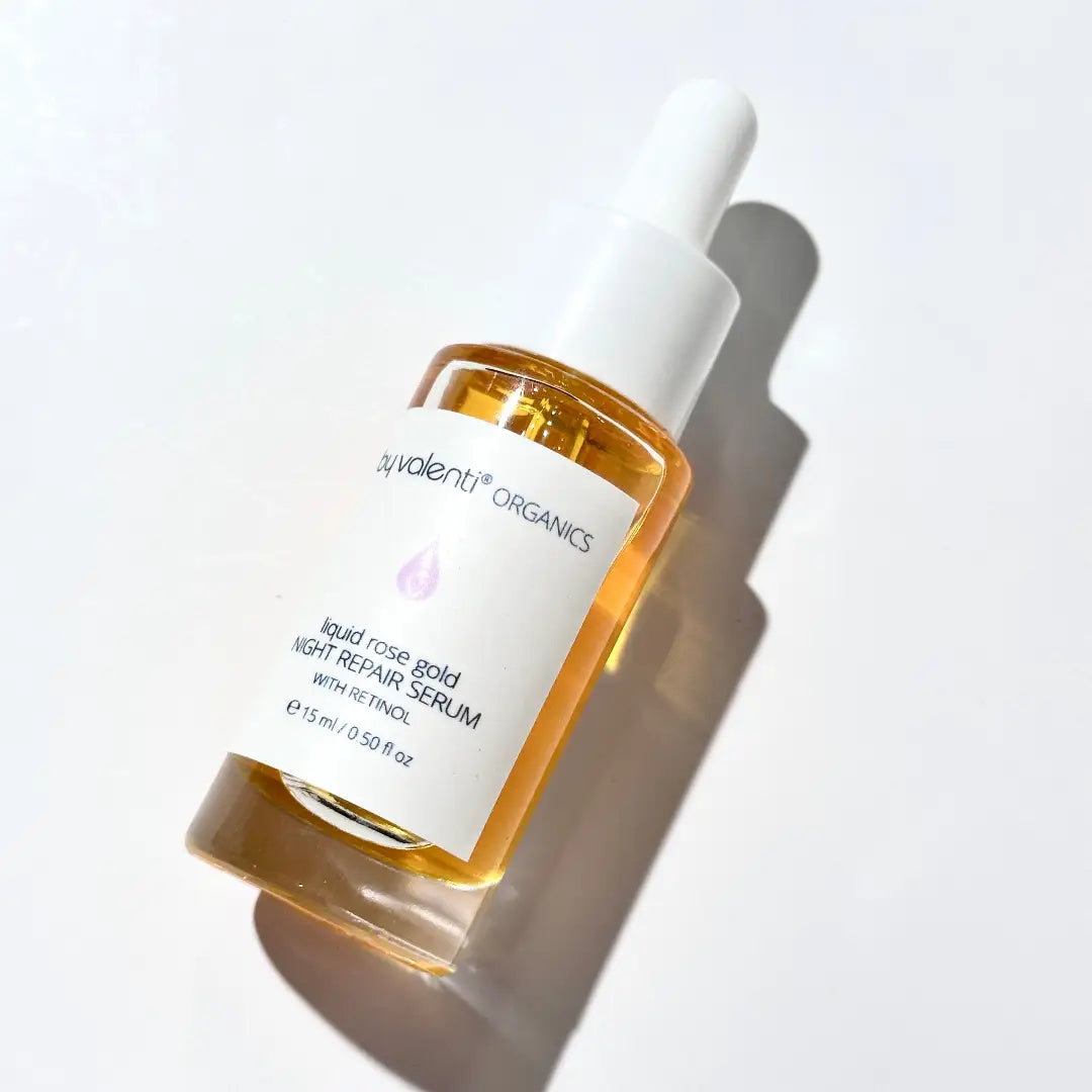 By Valenti skincare serum bottle with dropper on a light background