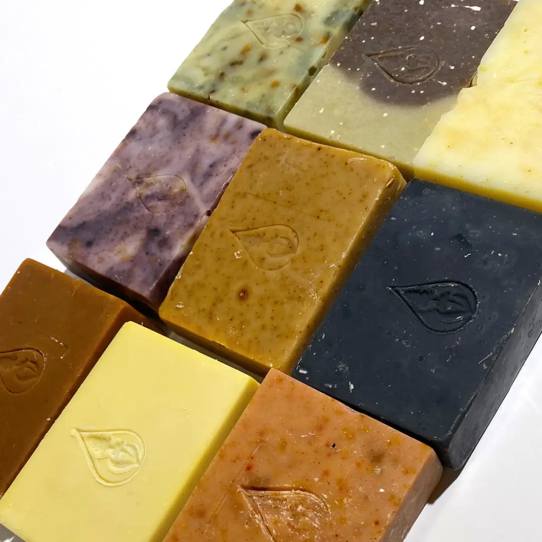 Assorted By Valenti bars of soap in various colors on a white background